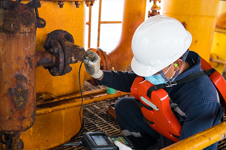 Inspector checking for biocorrosion with vibration device