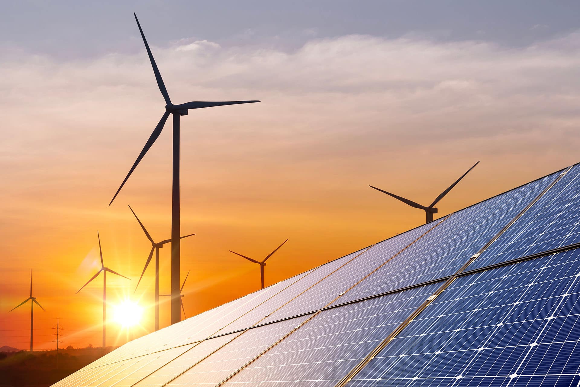 coatings for renewable energy seen on solar panel with windmills in the distance