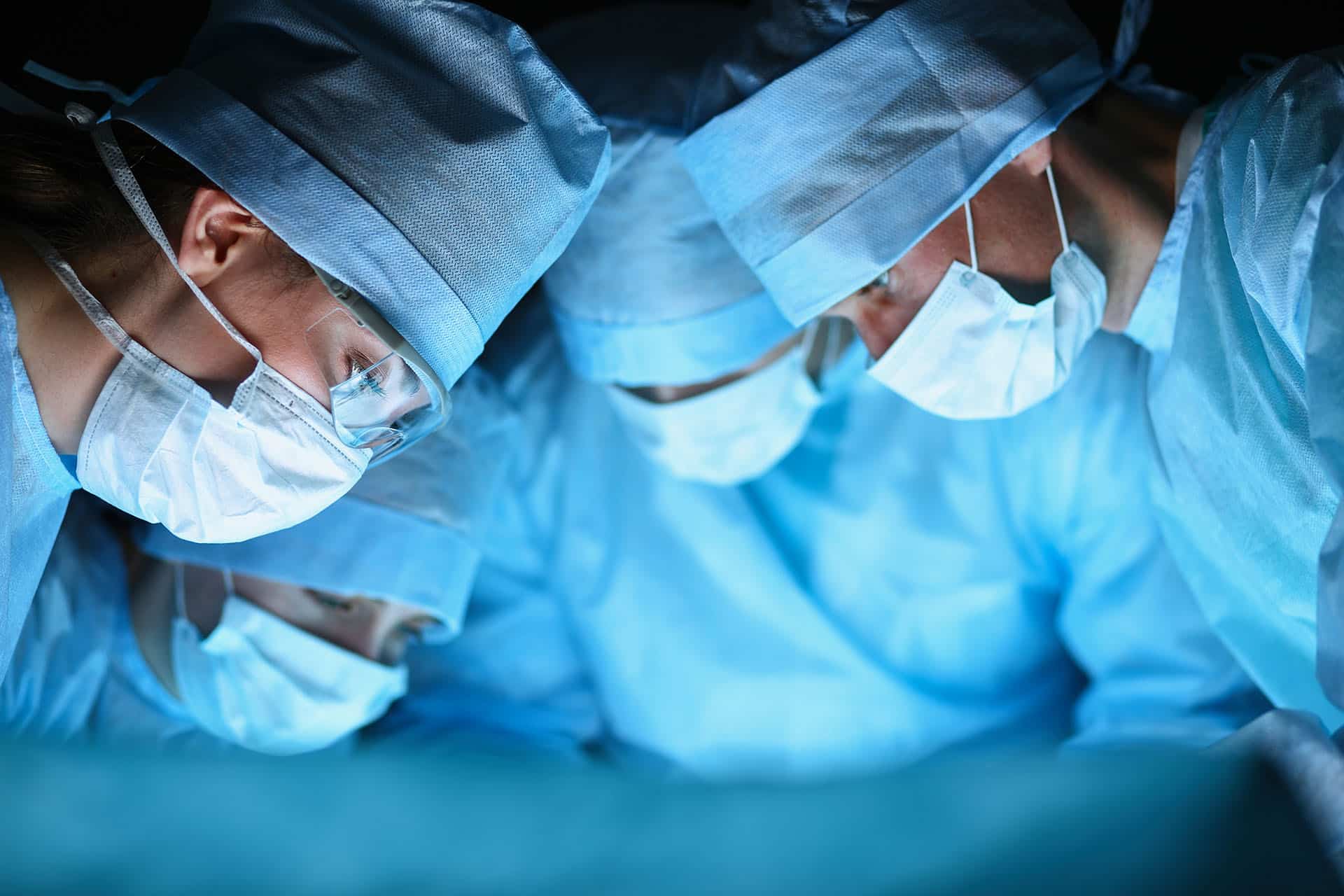 Surgical team looking down on completed operation
